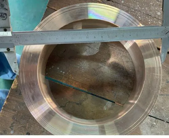 Bore of a machined copper nickel ring flange being measured with a steel rule